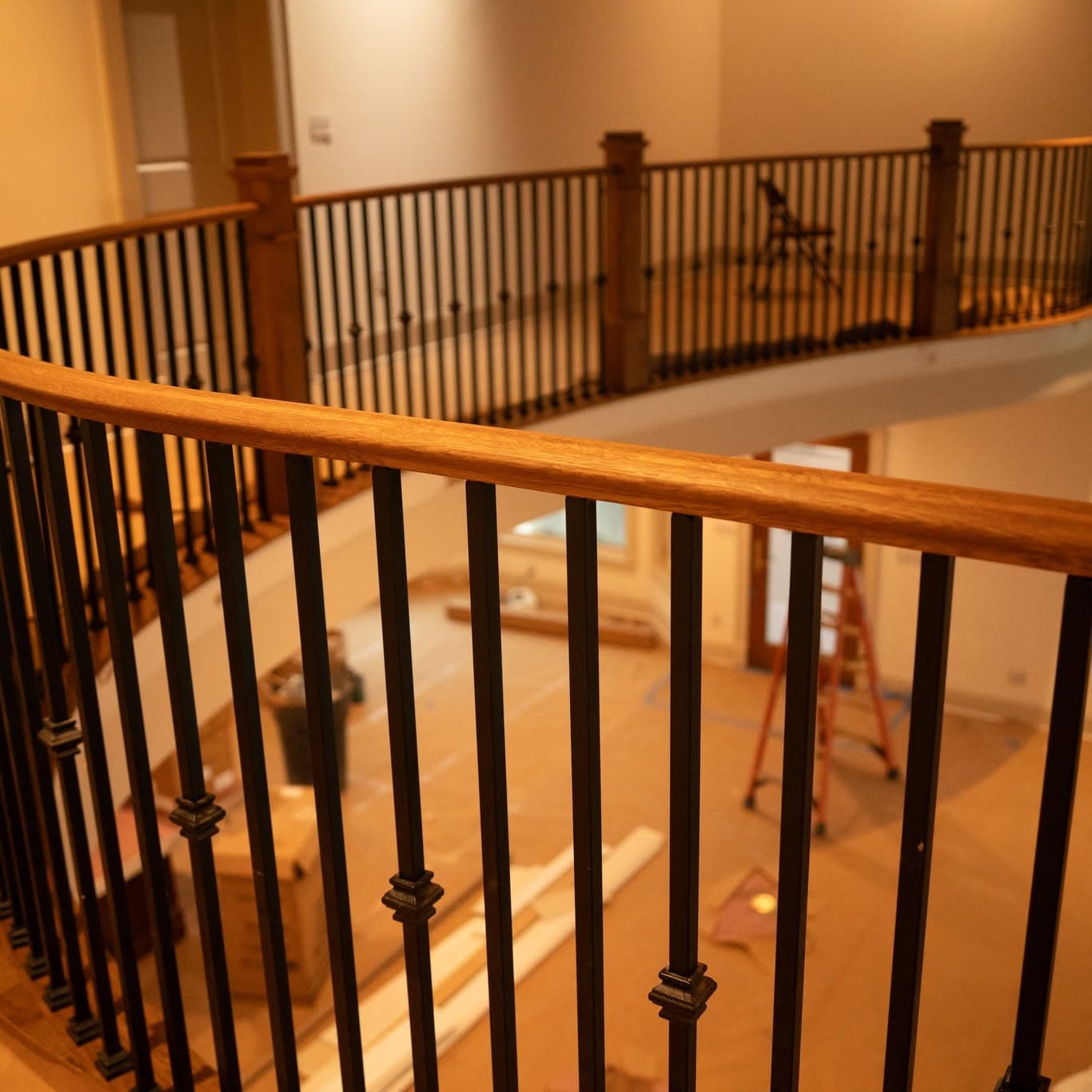 Upper balcony/landing railing with black balusters and oak cap overlooking foyer