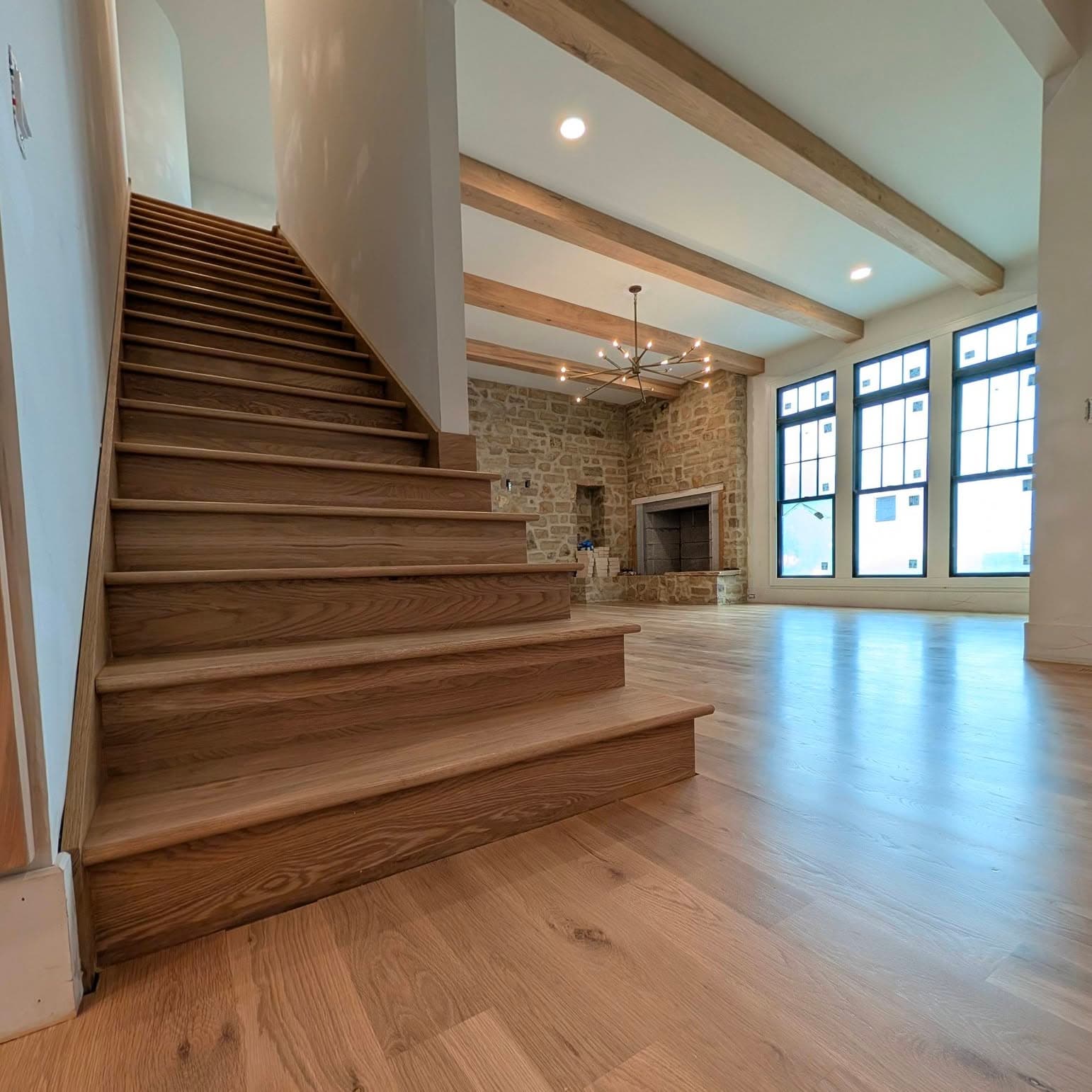Interior room with a flight of light wood stairs rising on the left