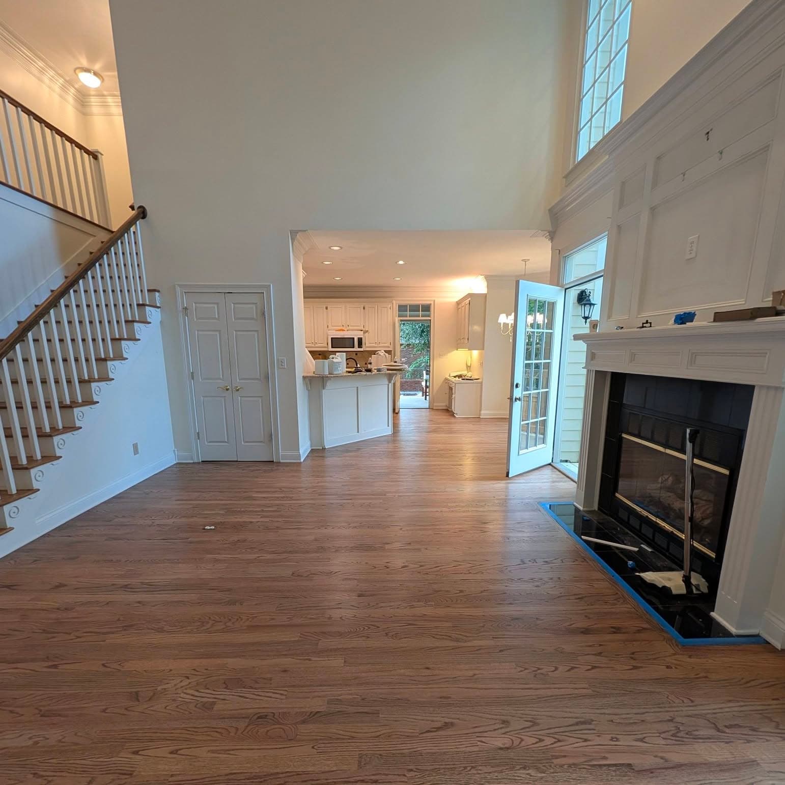 Living room with fireplace; wooden staircase and banister visible at left
