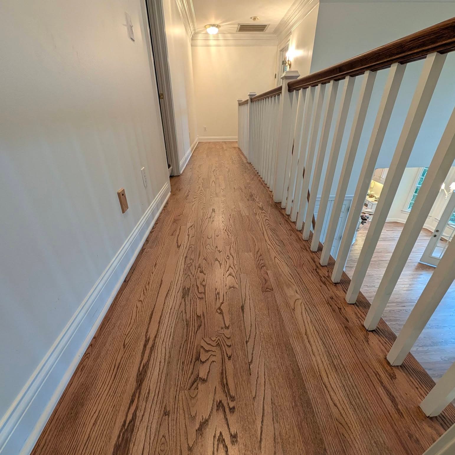 Upper landing with decorative white railing overlooking the lower floor