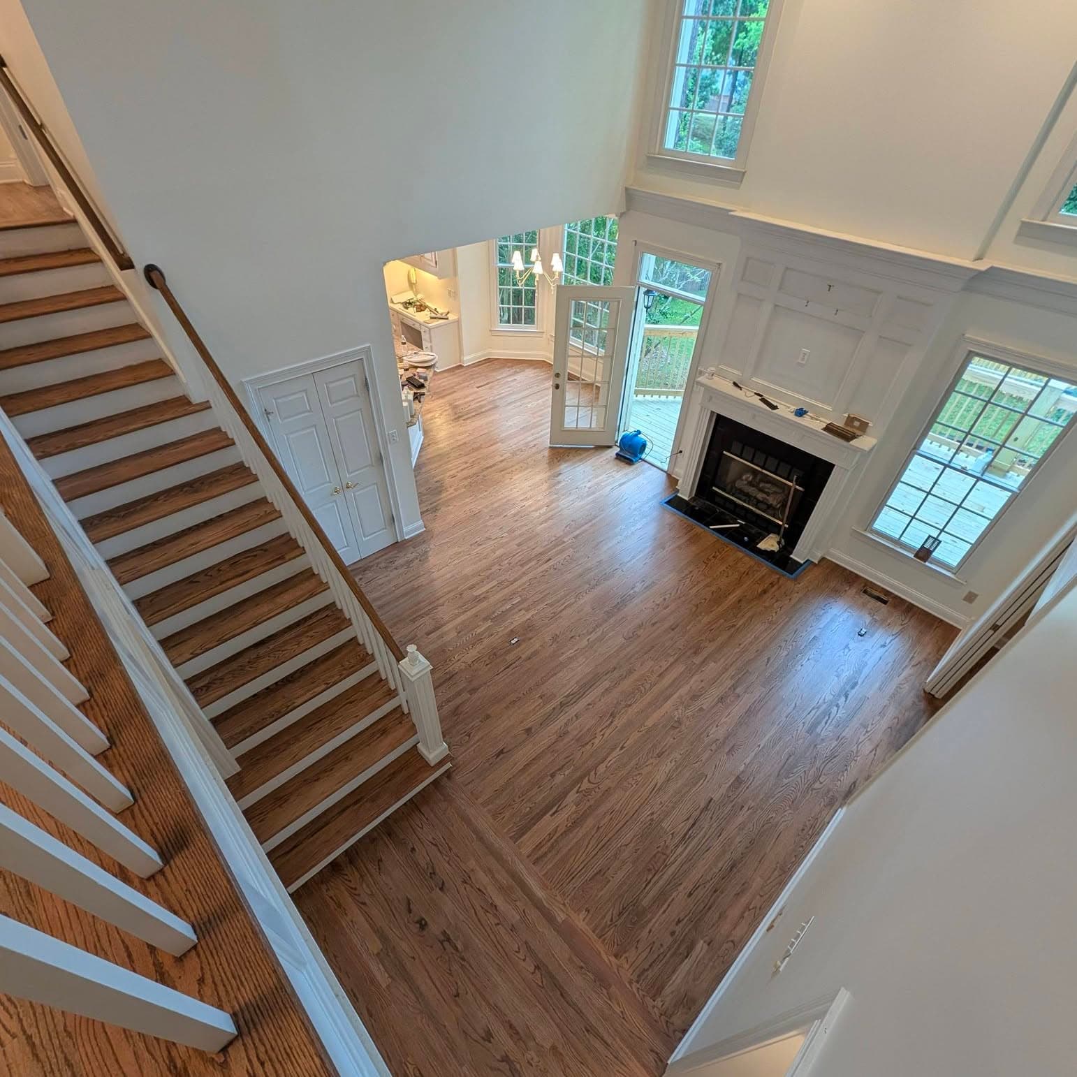 High-angle view into living room with white-railed staircase at left