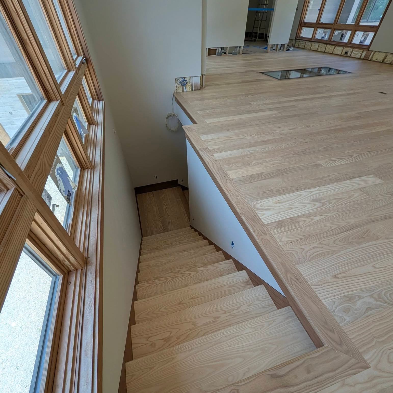 High-angle view looking down a straight light wood stair