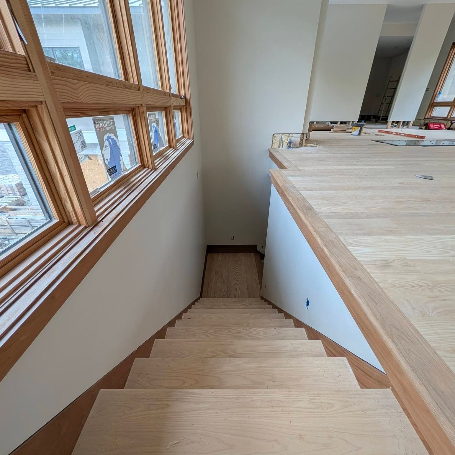 Looking down a run of light wood stair treads
