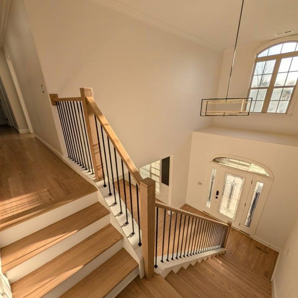 Wide wooden stair with white risers and wood-and-metal railing