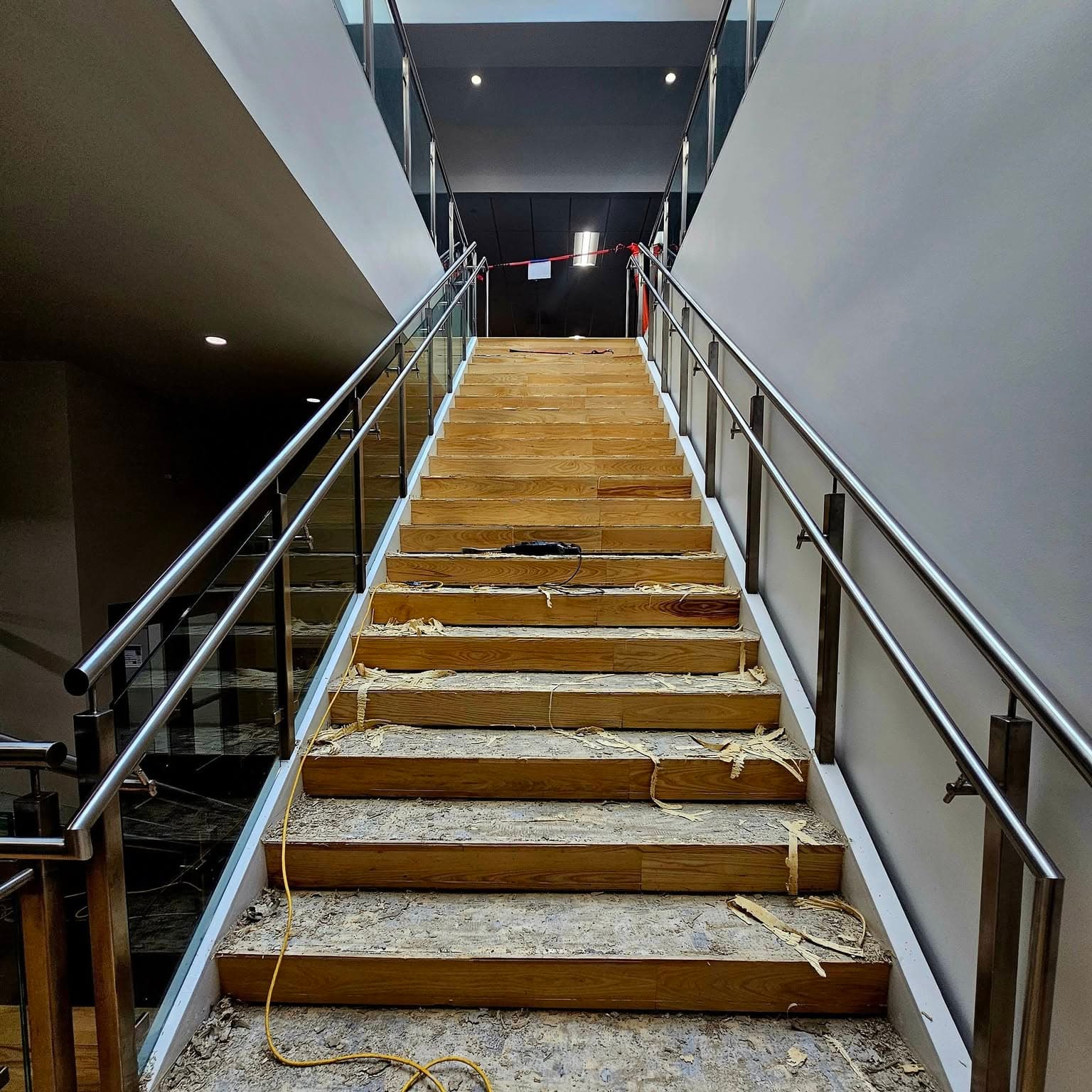 Looking up a newly finished wooden stair with metal handrails