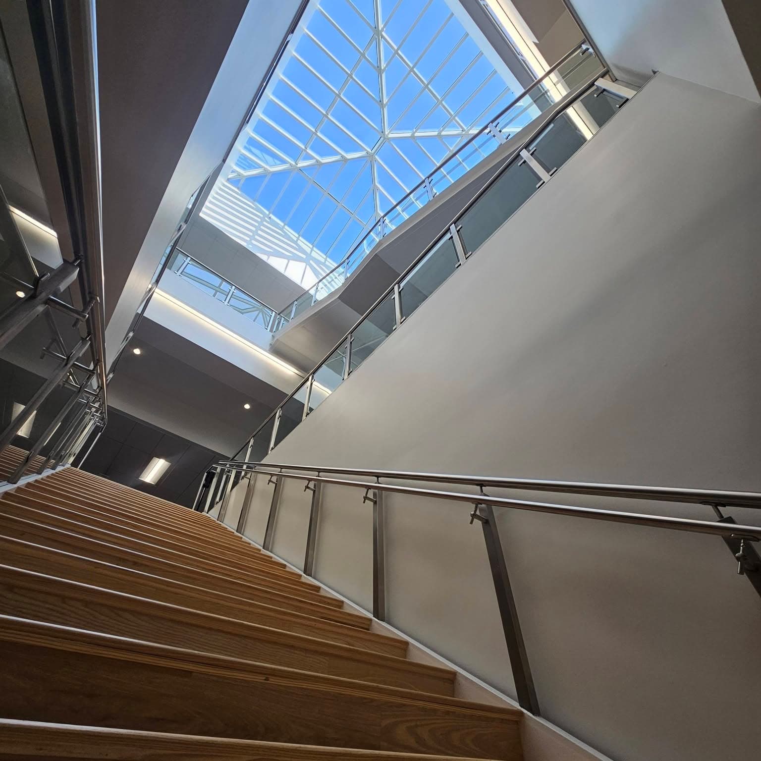 From the base looking up a modern stair toward a skylight