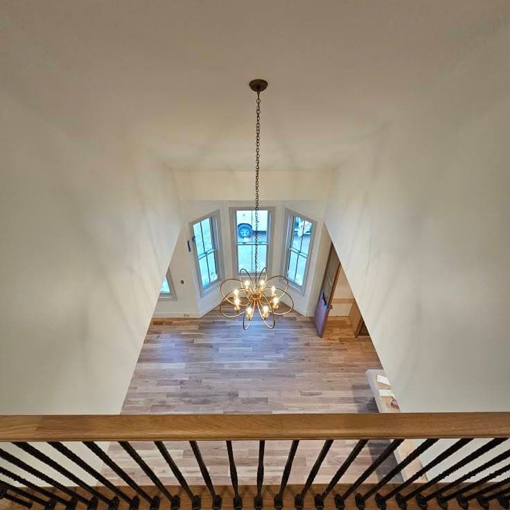 From an upper landing looking over a wooden balustrade into the living area