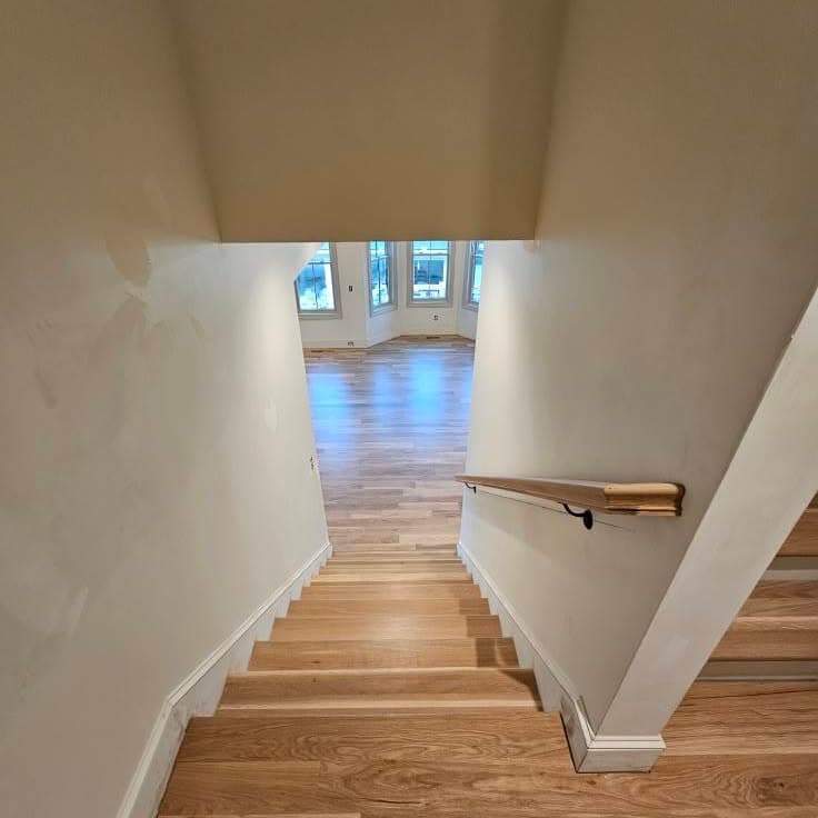 Looking down a wooden staircase from the top landing