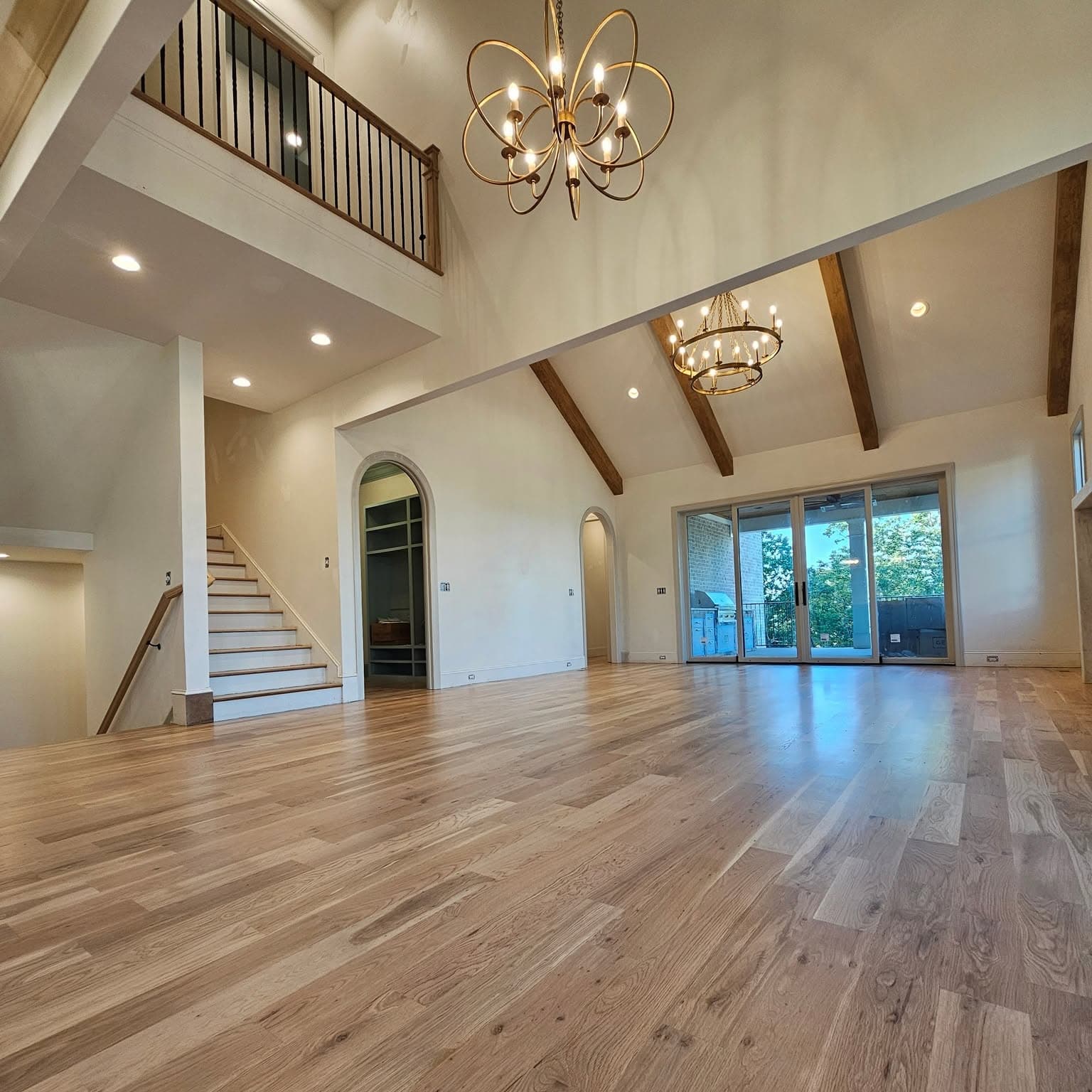 Large living area; wooden-handrail staircase at far left to the second floor