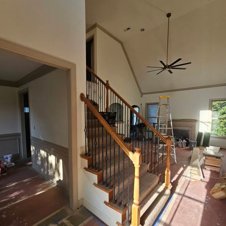 Stair with light wood handrail and dark metal balusters