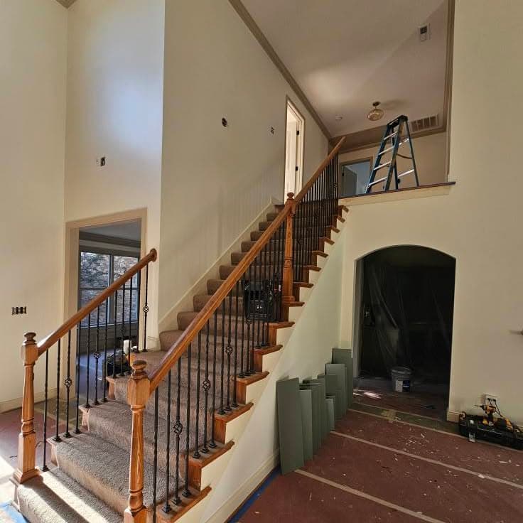 Finished stair with light wood handrail and dark metal spindles