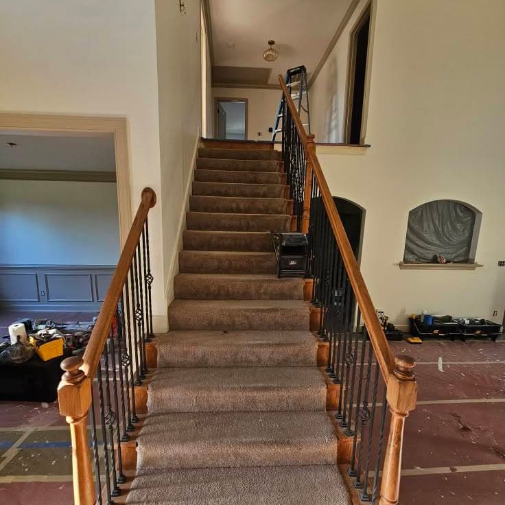 Stair with wood handrail and metal balusters, treads paper-protected