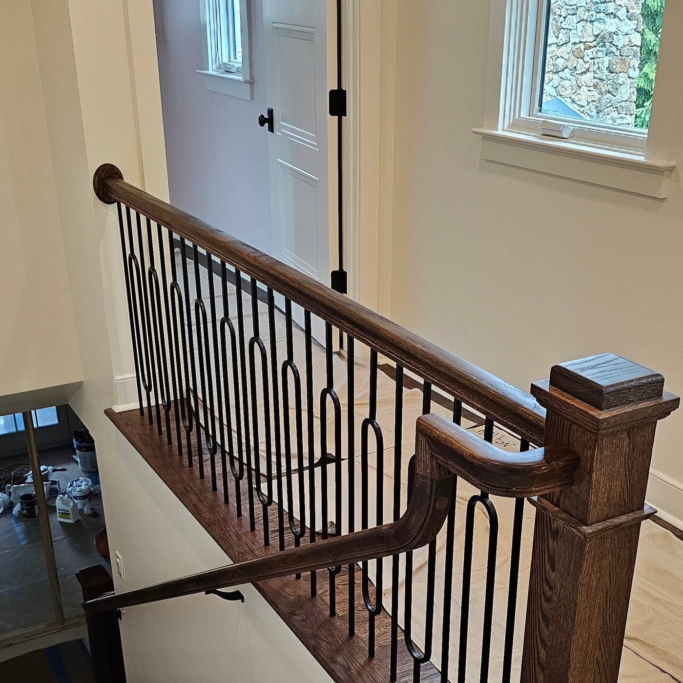 Angled view through decorative metal balusters and a wooden handrail