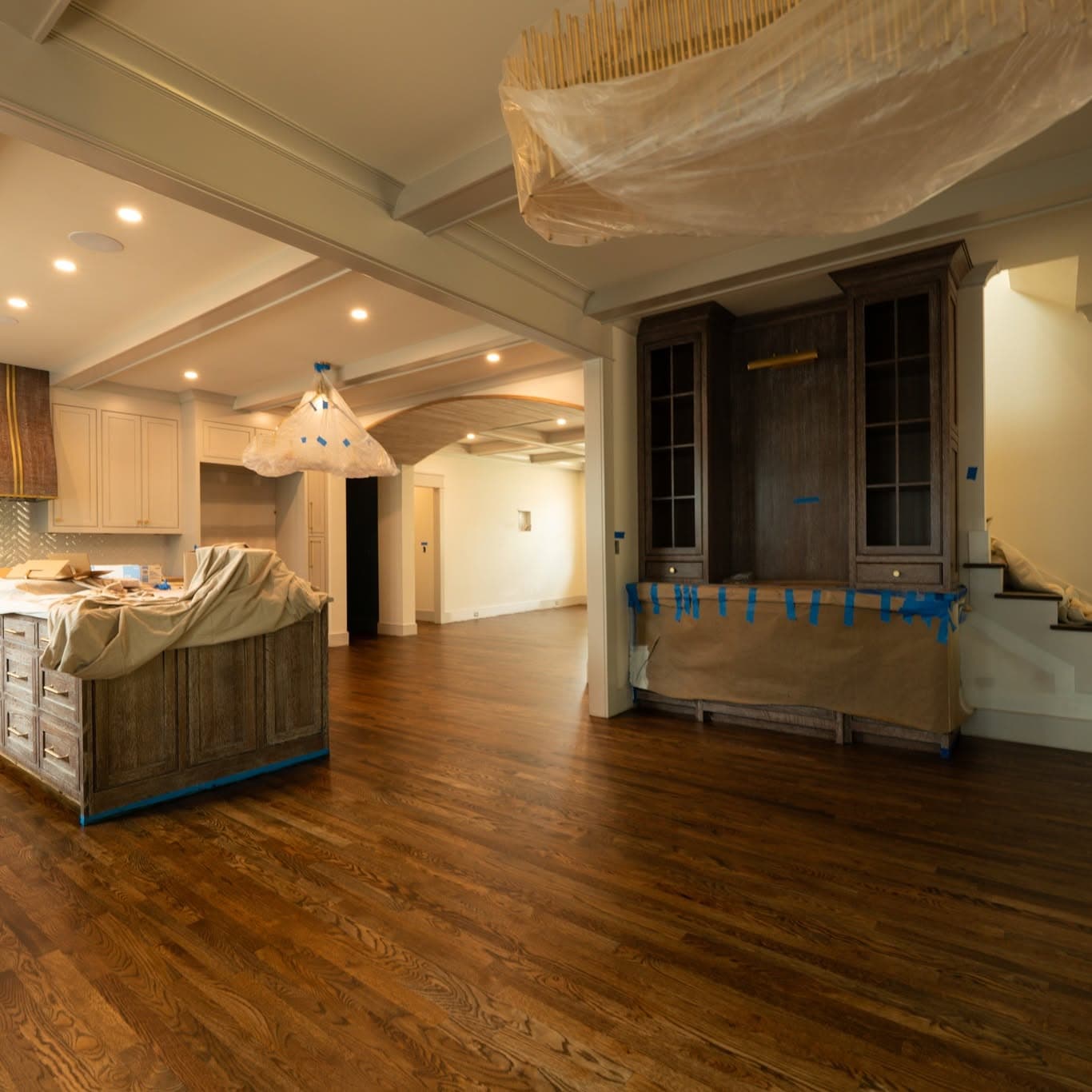 Wide renovation interior; partial stair at right with white risers and handrail