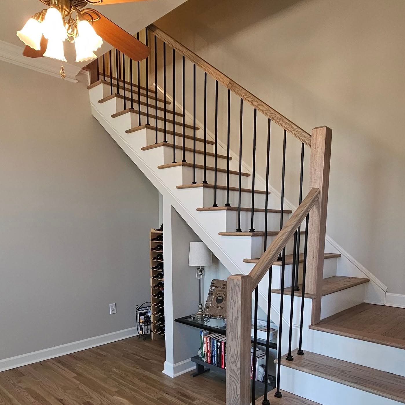 Wider view of the same stair from the base across light wood flooring
