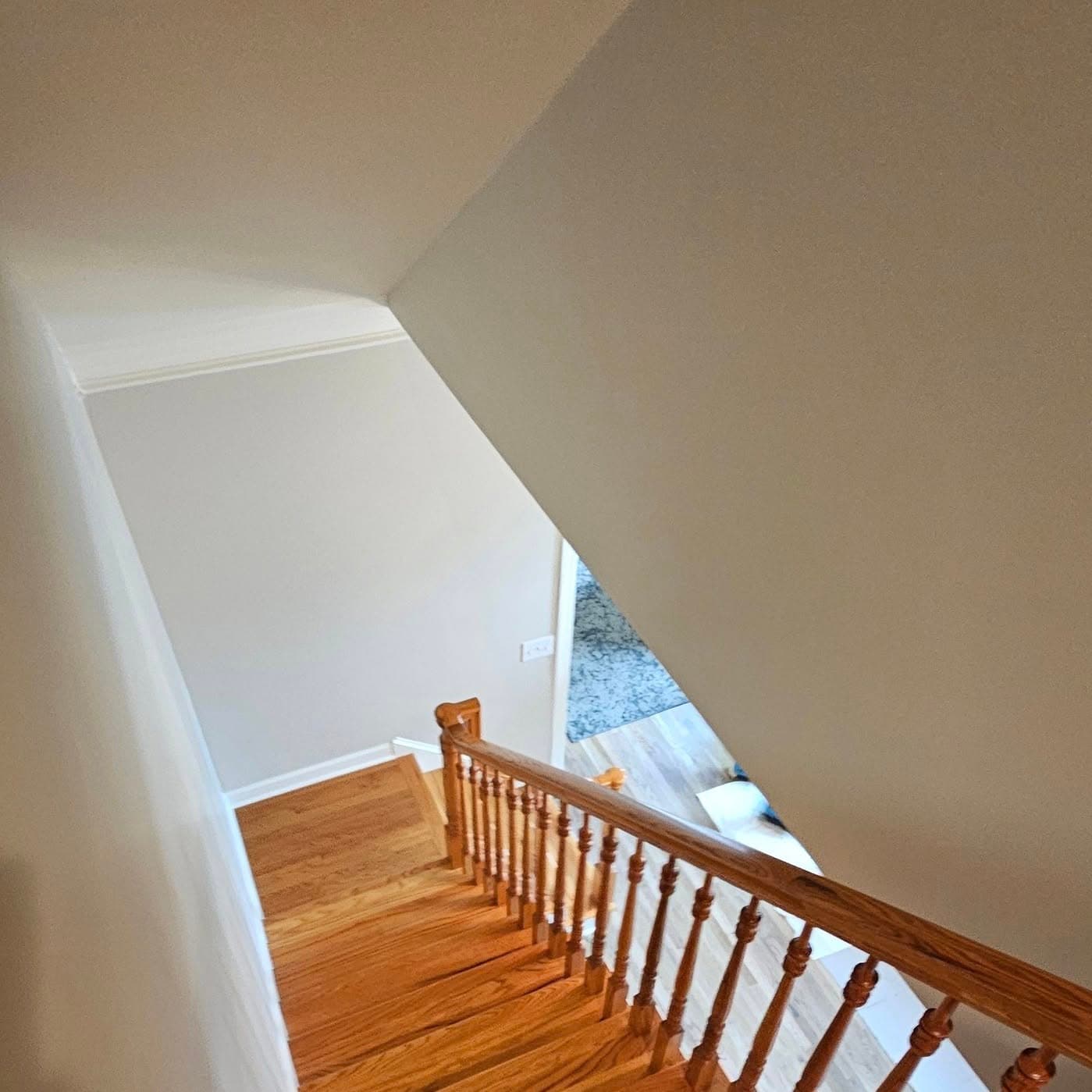 Looking down from a landing; traditional wood handrail and wood balusters
