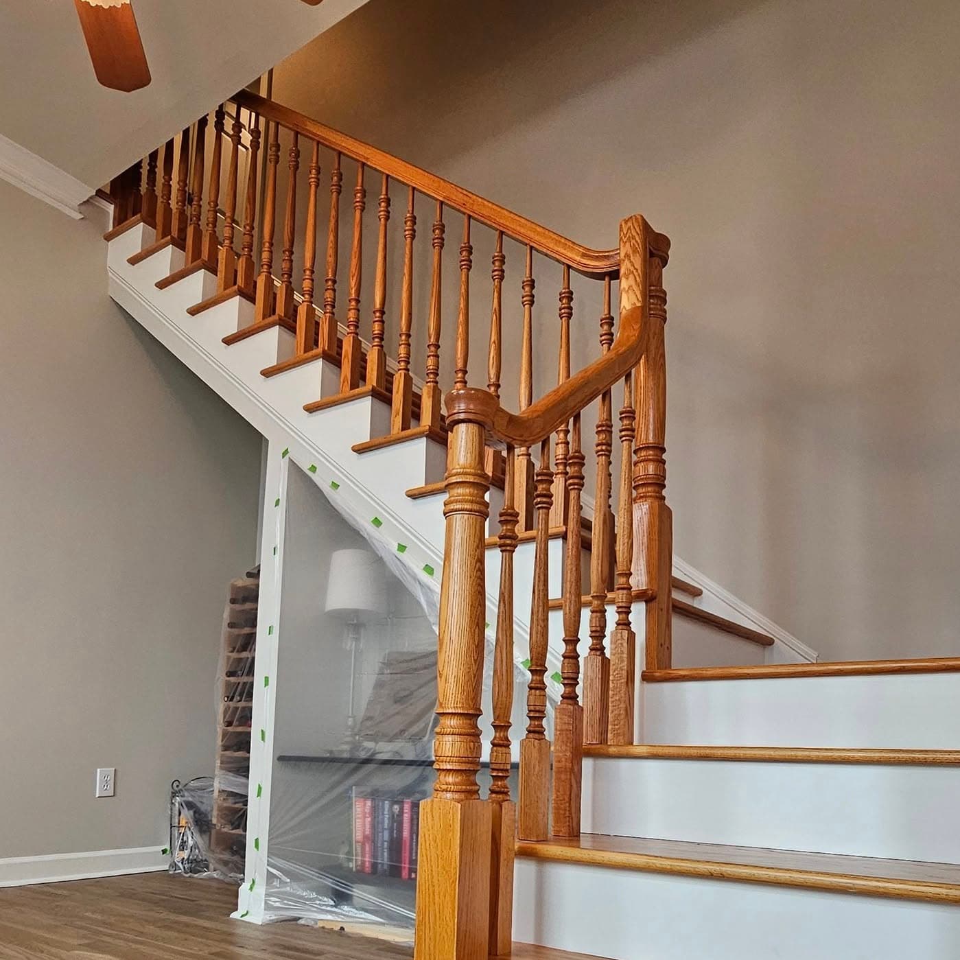 Curving stair with light treads, white risers, wood handrail and white spindles