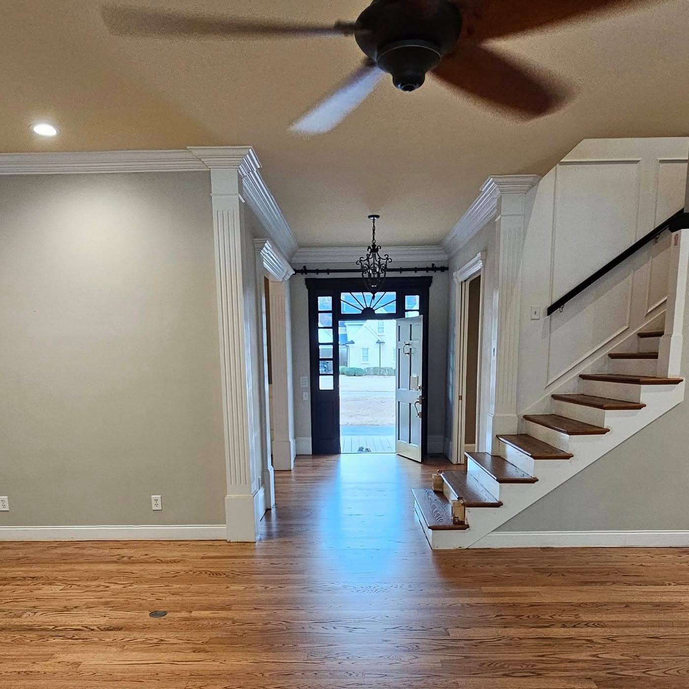 Open-plan living area; staircase with wooden treads and handrail at far right