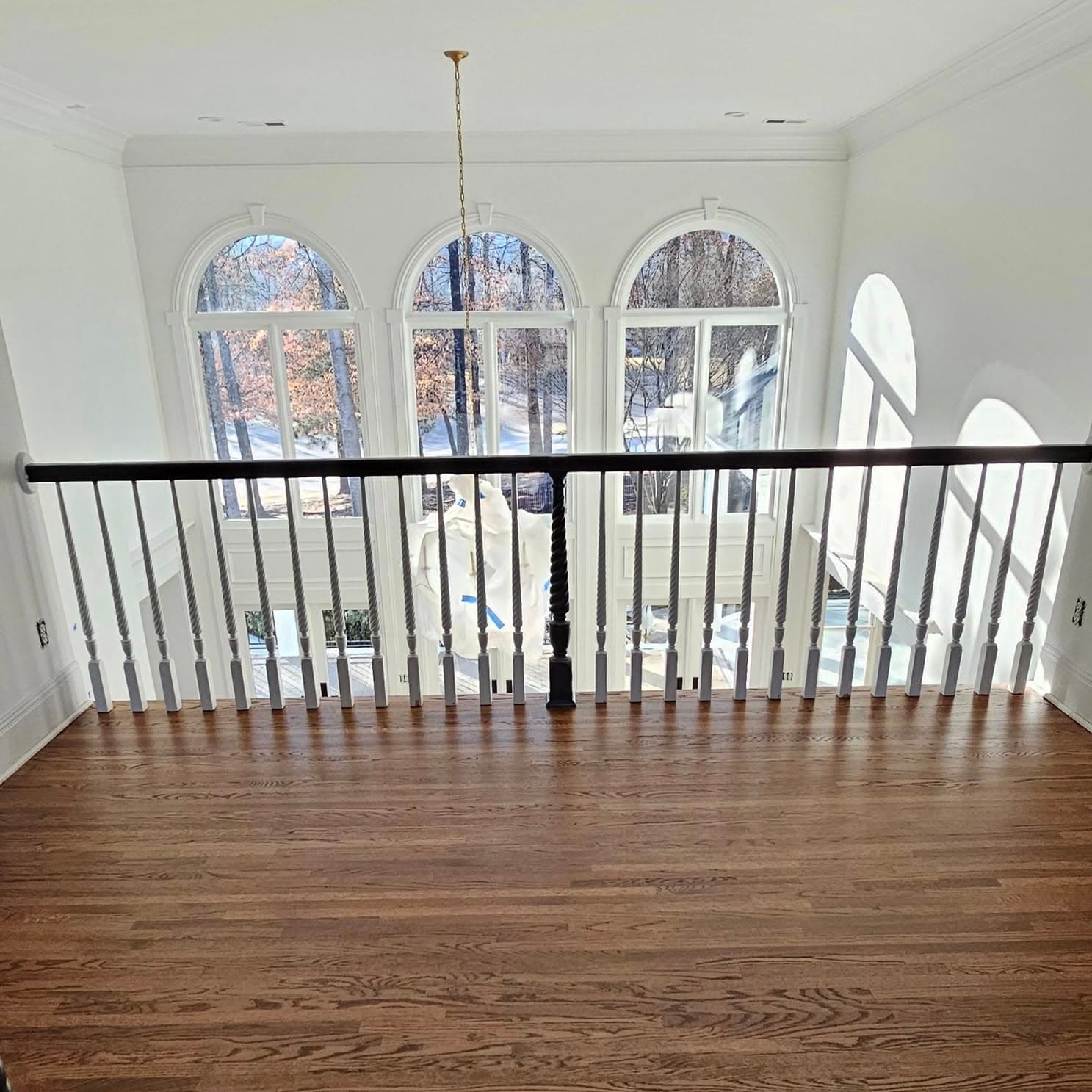 Upper landing hallway with white balusters and dark wood handrail