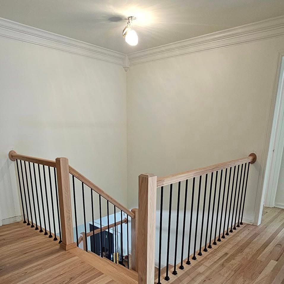 Landing/stairwell top railing, light wood cap with black metal spindles