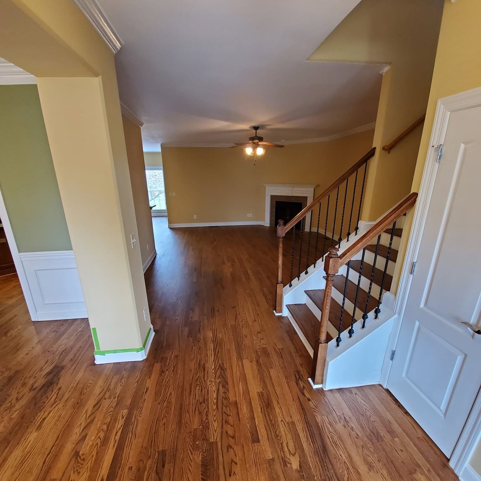 Living space; wooden stair with white spindles and dark wood handrail at right
