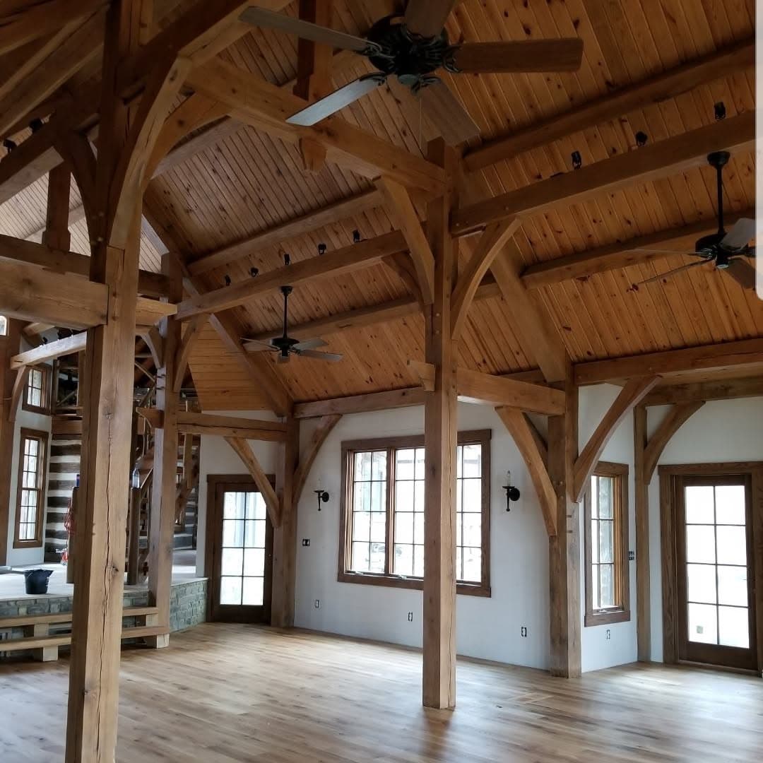 Timber-frame hall; heavy wood/log staircase partially visible at left