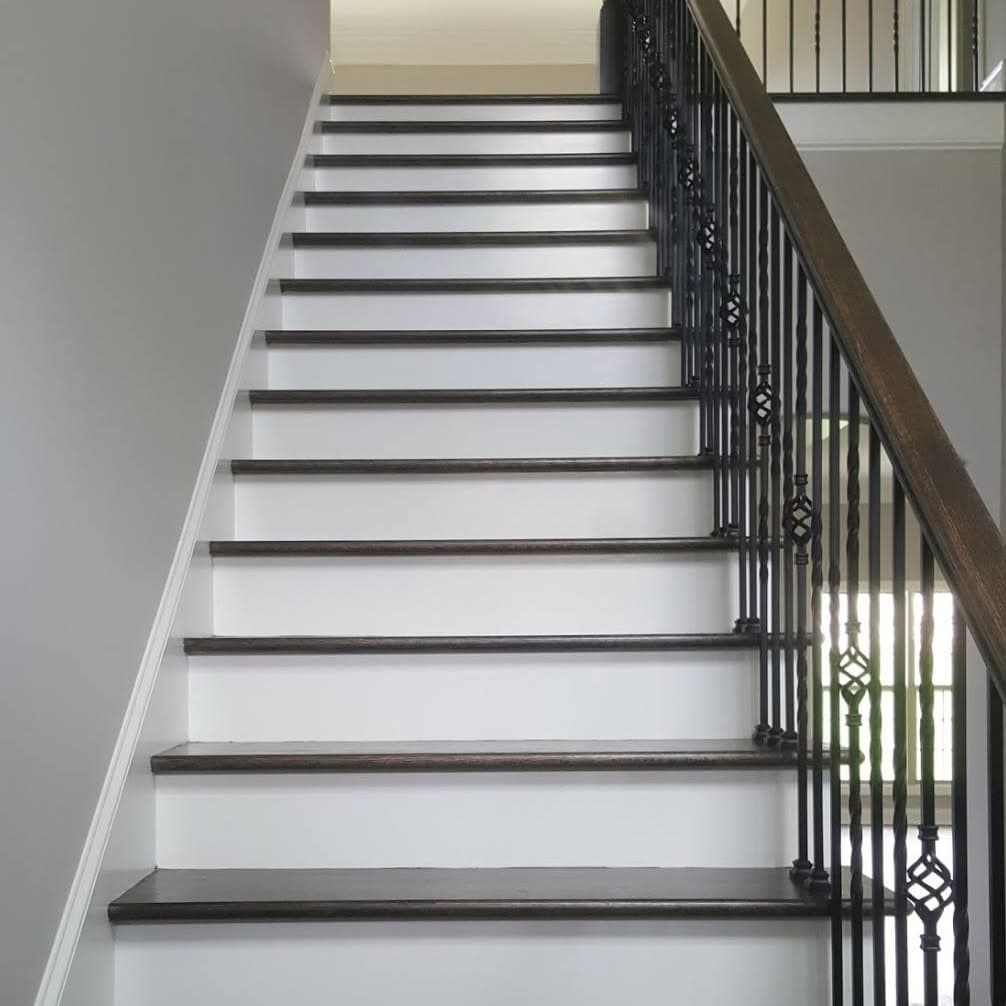 Full flight with dark wood treads, white risers/stringers, and black metal railing